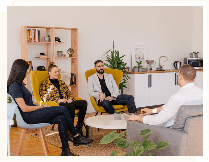 A group of people sitting in chairs around a table.